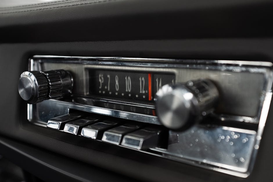 Detailed view of a classic car radio dashboard with chrome knobs and buttons.